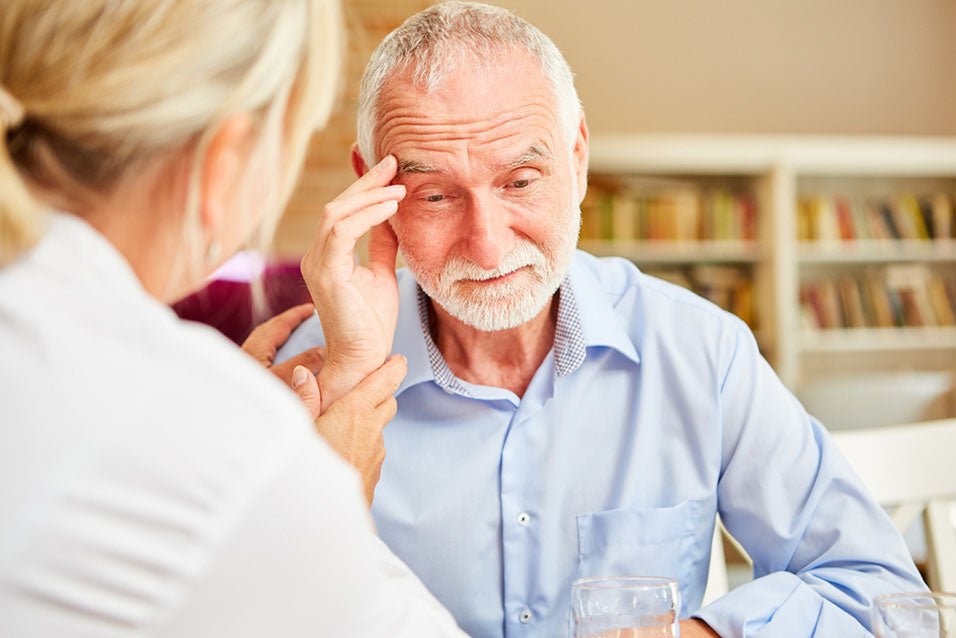 A senior with dementia being comforted by his doctor