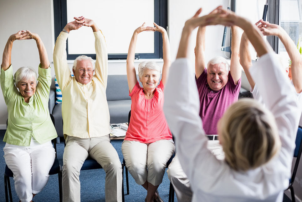 sitting seniors stretching arms upward