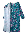 A long-sleeve tunic dress with a split design: one side features a dark teal floral print with pink, purple, and green flowers, while the other side shows a light gray floral lining. It has black shoulder straps with silver buttons at the neckline.