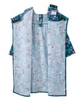 A sleeveless poncho-style garment with a light blue-gray floral print and teal green trim, displayed flat against a white background.