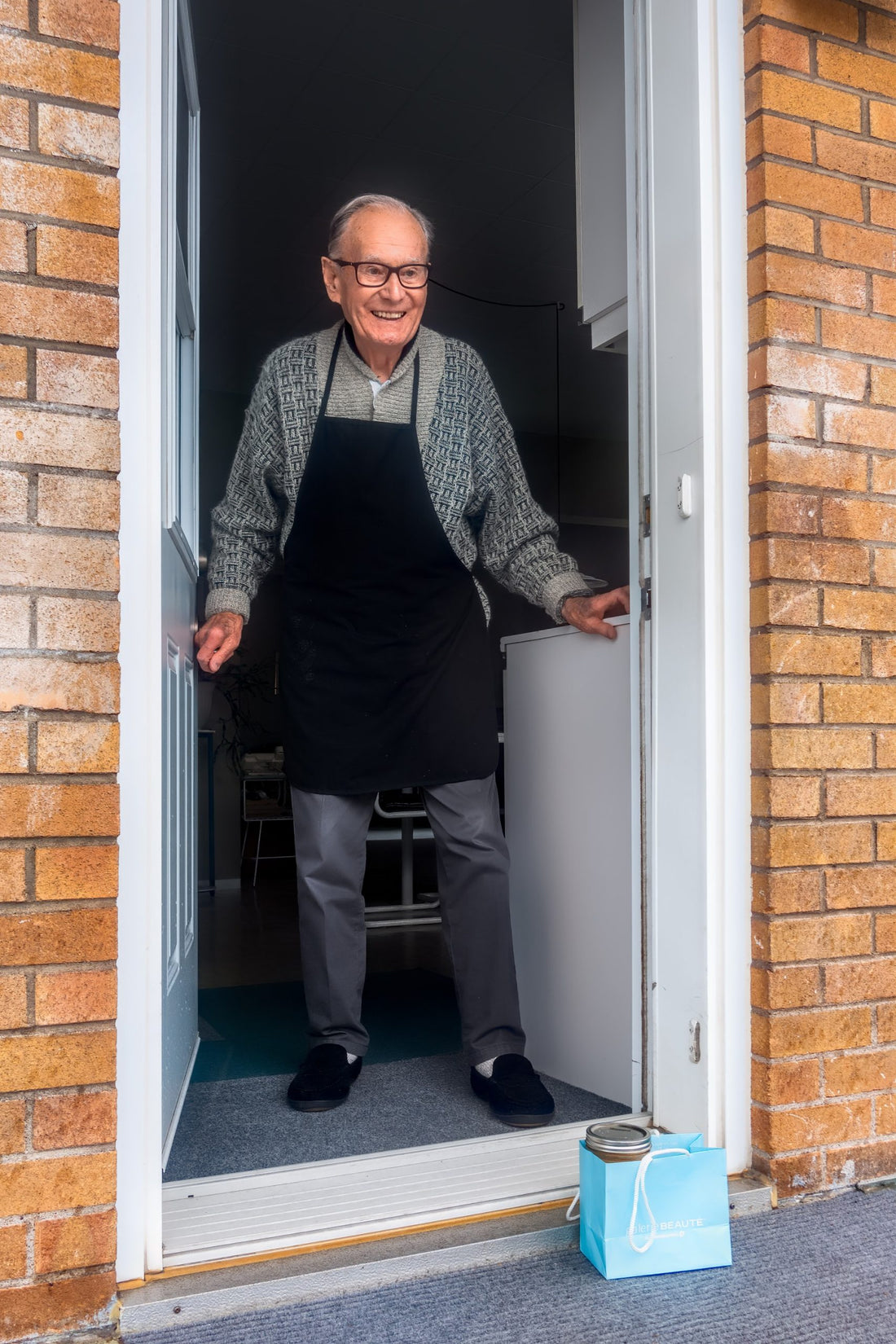 Grandfather is greeted at front door with a gift.