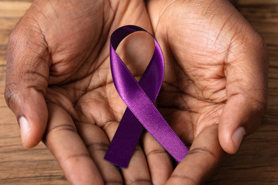 Close-up Of A Person's Hand Holding Ribbon To Support Alzheimer's Disease Awareness