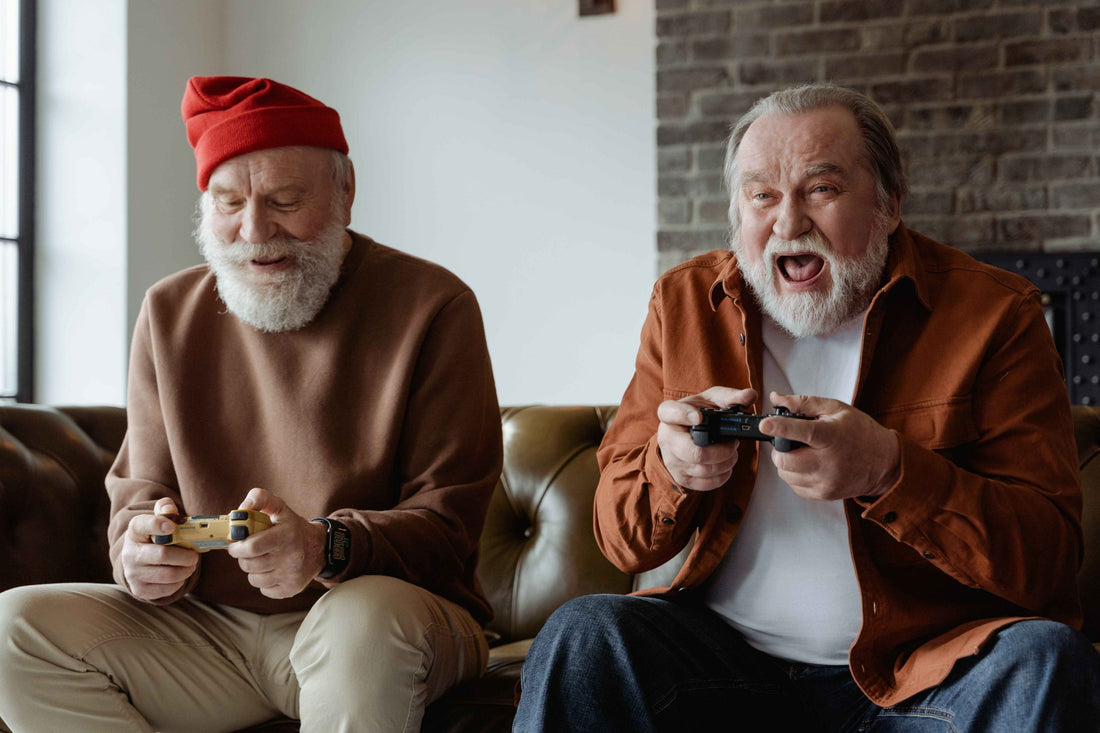 Two older men sitting on a couch playing video games
