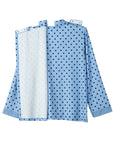A light blue long-sleeve hospital gown with dark blue polka dots, shown with the front and back panels overlapping on a plain white background.