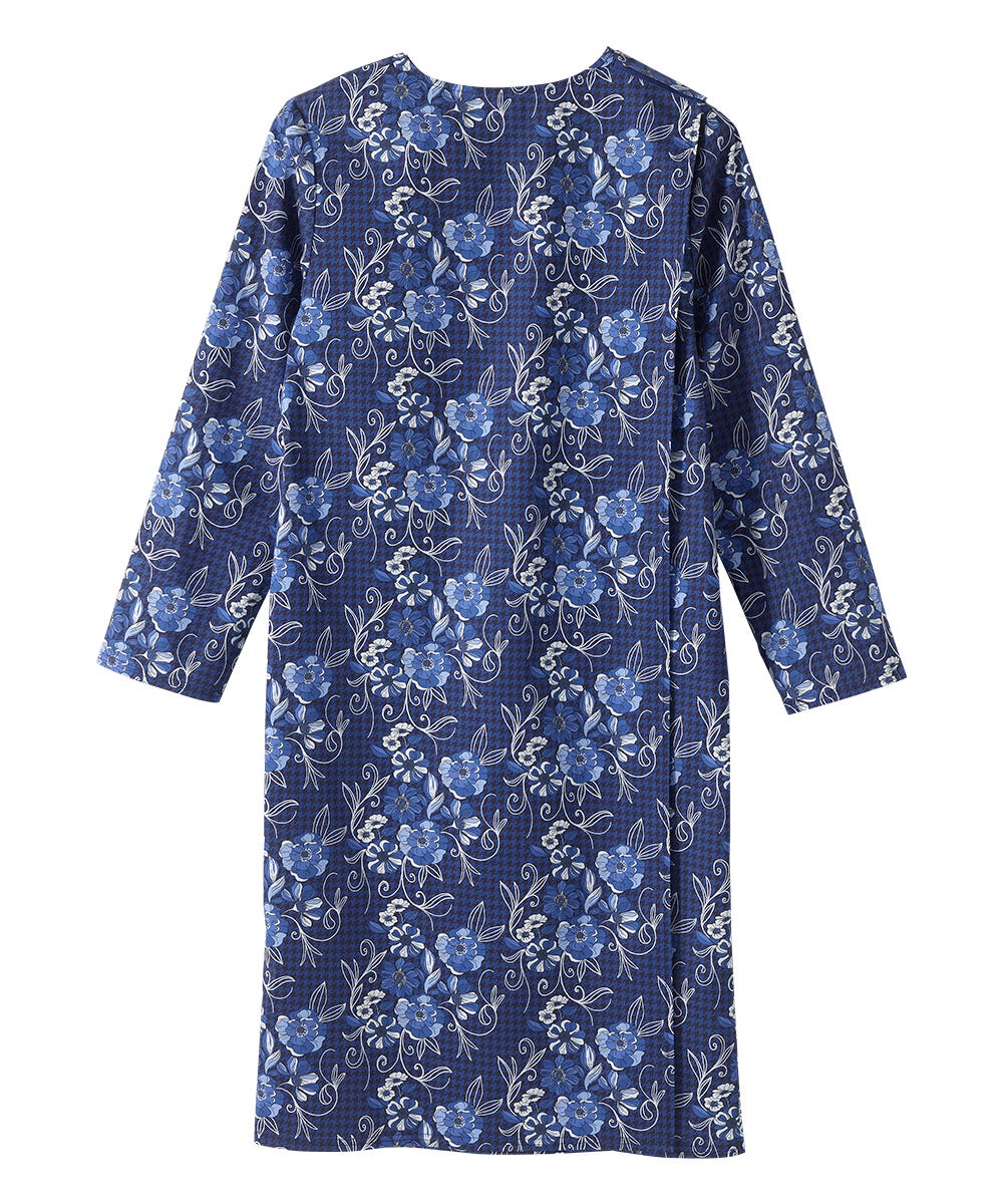 A long-sleeve blue dress with a white floral and vine pattern, shown against a plain white background.